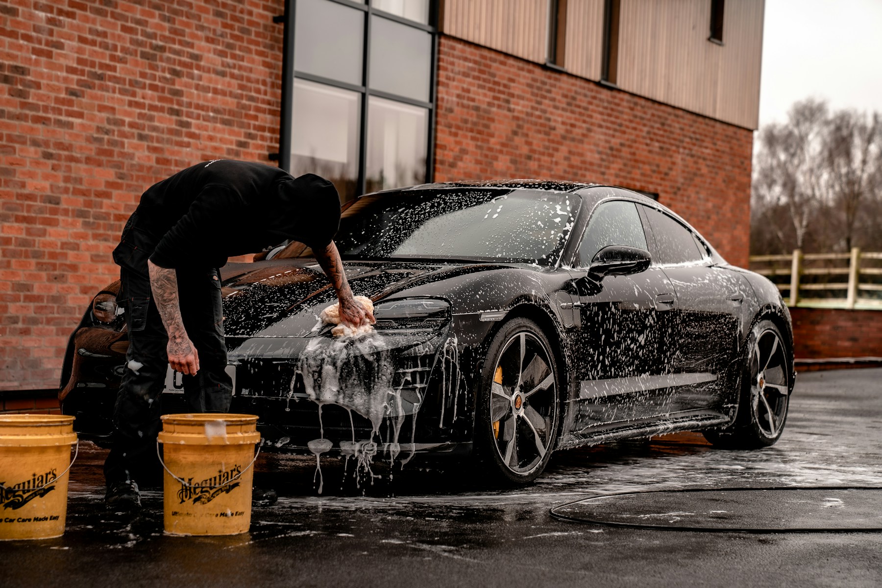 A black performance car being carefully hand washed